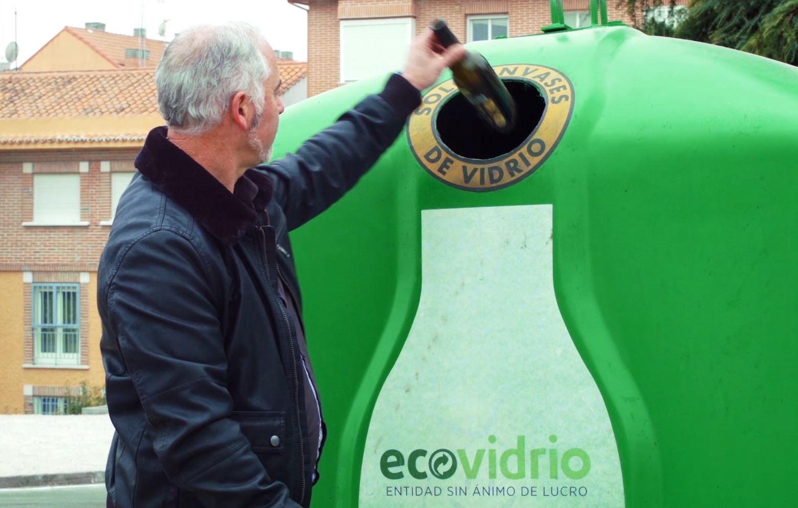 Depositando botella de vidro no iglú verde