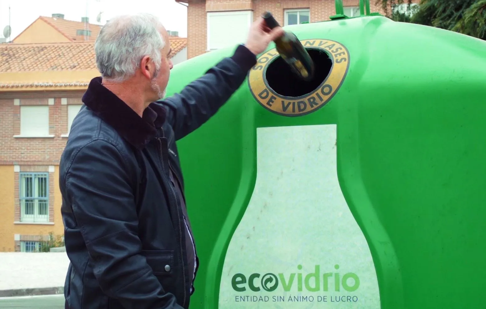 Depositando botella de vidro no iglú verde